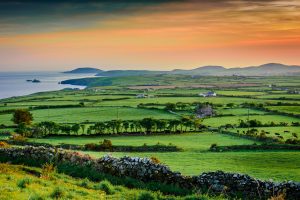 Arfordir Cymru a chaeau ar fachlud haul